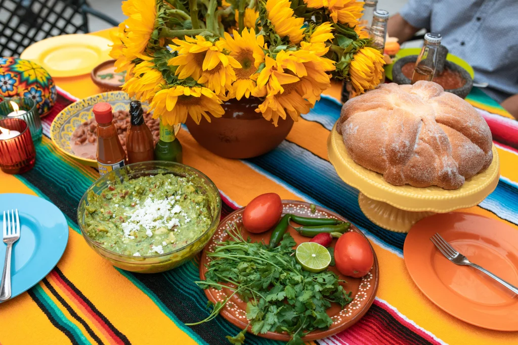 food in plates next to a pot full of sunflowers