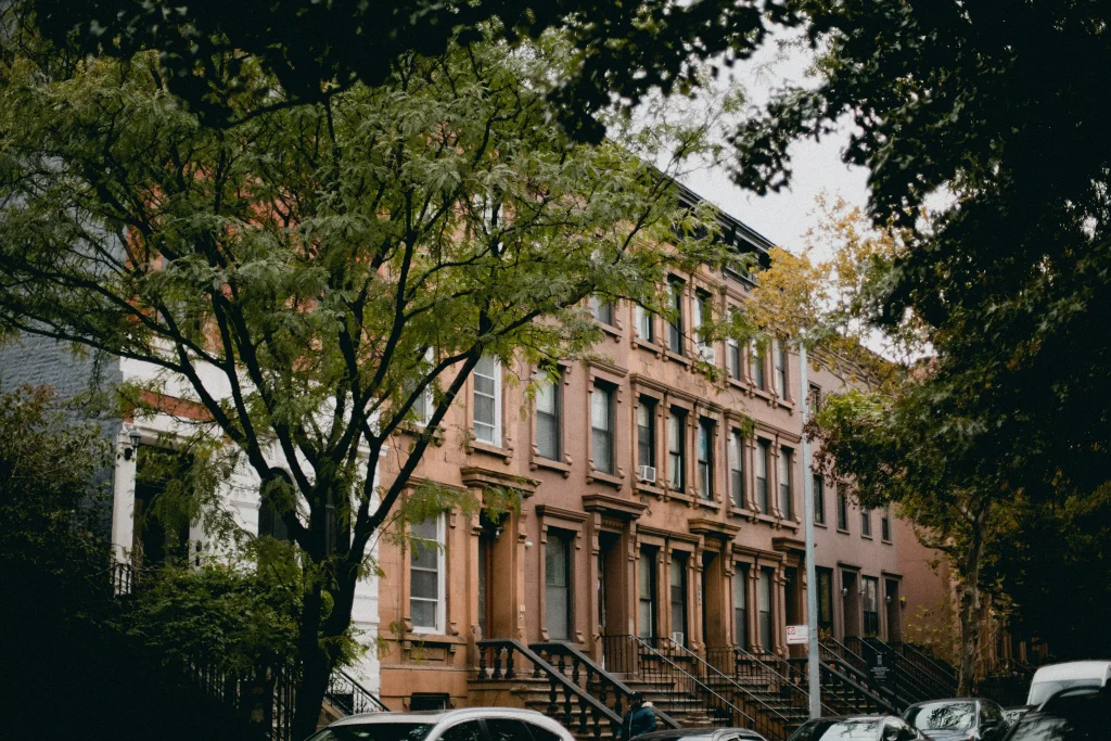 a brick house photographed from behind a tree