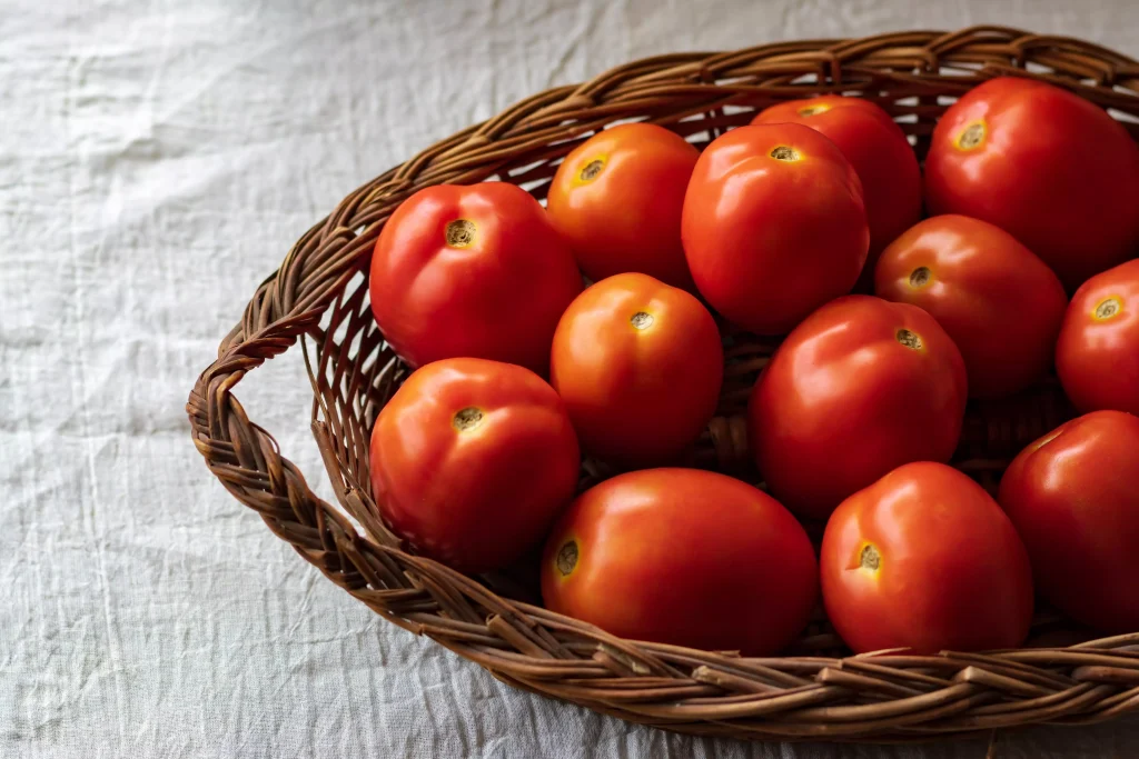 freshly picked and cleaned tomatoes in a wooden bowl