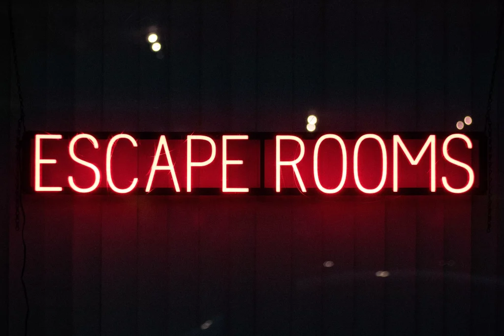 neon sign that says escape rooms