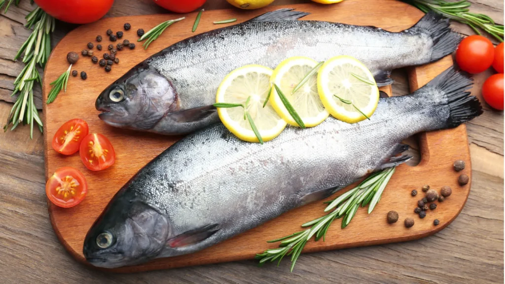 two fishes with lemons on top being prepared for cooking