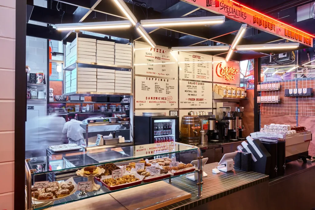 a bakery with a menu above the breads which are in glass