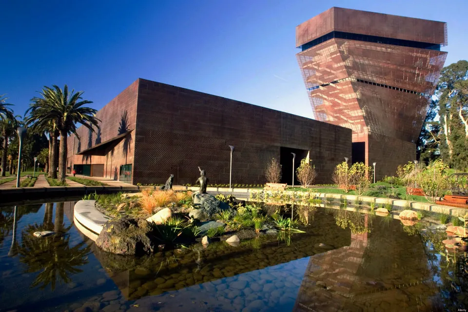 a modern looking building with a lake infront of it