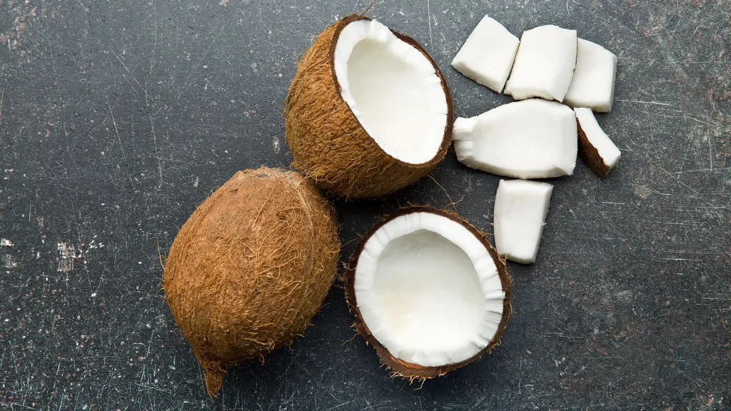 one whole and one sliced in half coconut