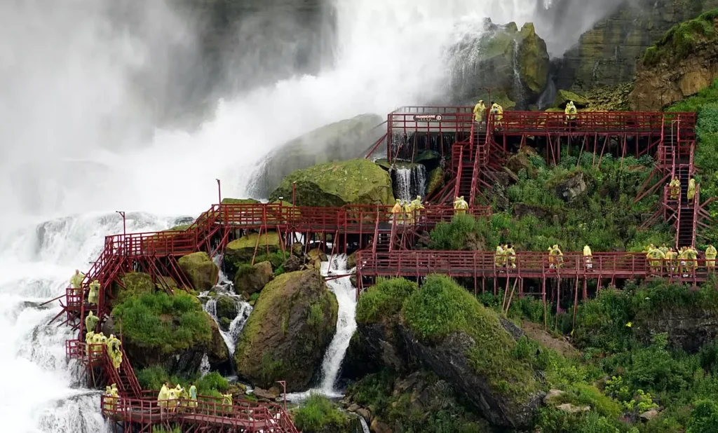 waterfalls next to a red building in a green field