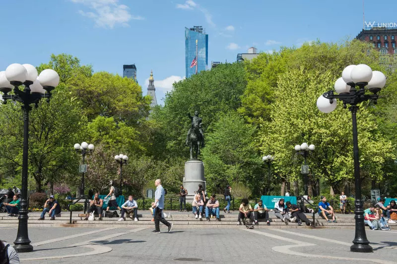 a road in a park of a bigger city full of people