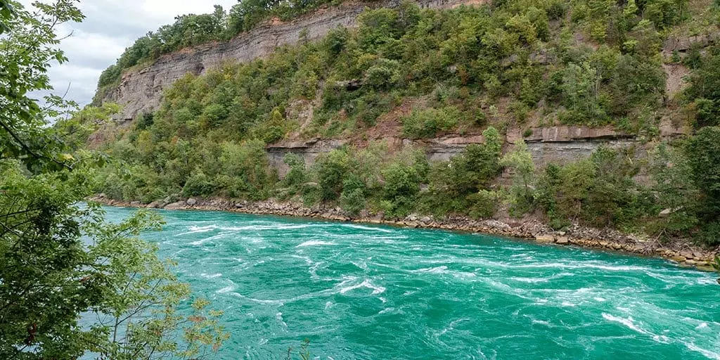 a river next to green mountains