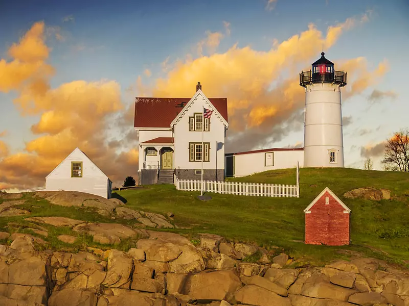 a white house next to a small wooden red house 