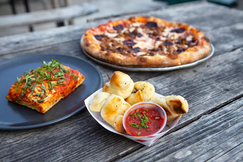 pizza and chicken nuggets on a black color wood table