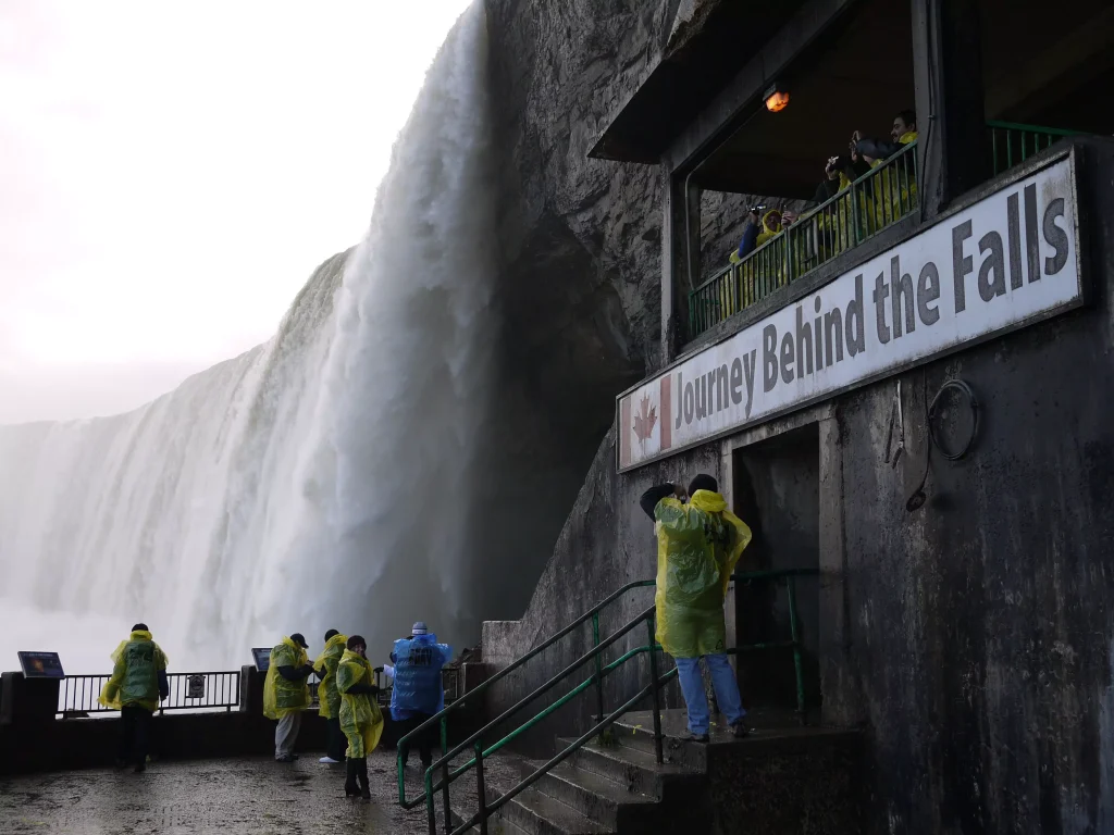 people in rain coats next to waterfall