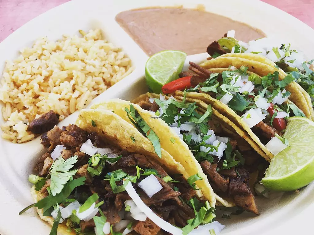 tacos and rice on a white plastic plate