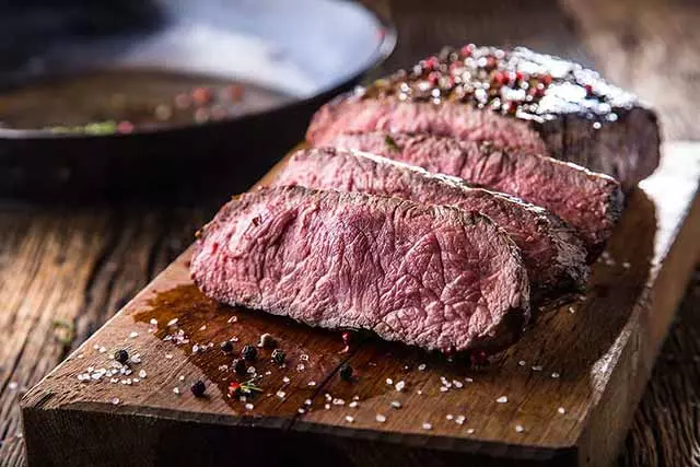 cooked red meat on a cutting board