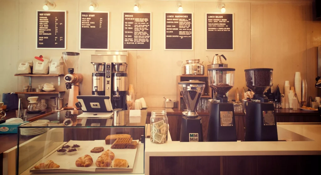 a counter in a restaurant with foods and coffee drinks on top of it