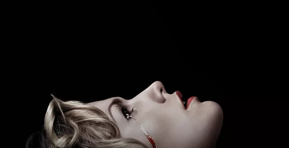 a girl with blonde hair and lipstick laying in a bed