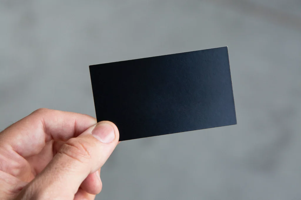 a person holding a black color card in their hand