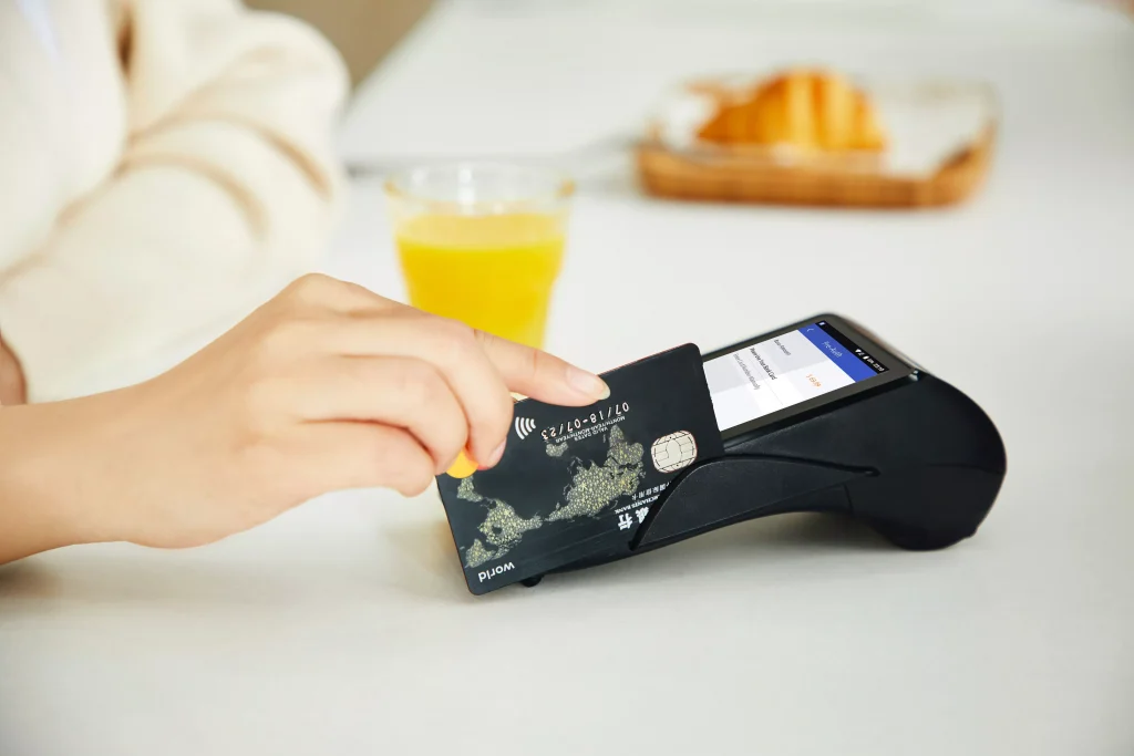 a person using a credit card to pay something at a restaurant