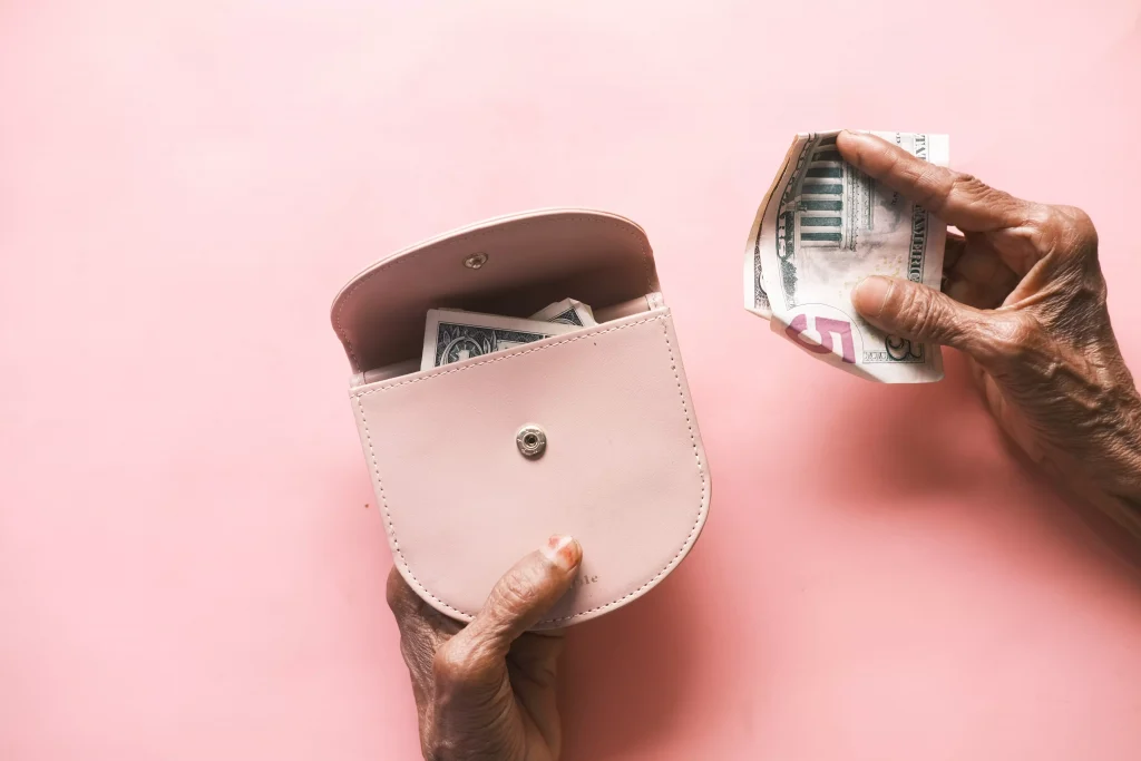 a person putting money in a pink bag