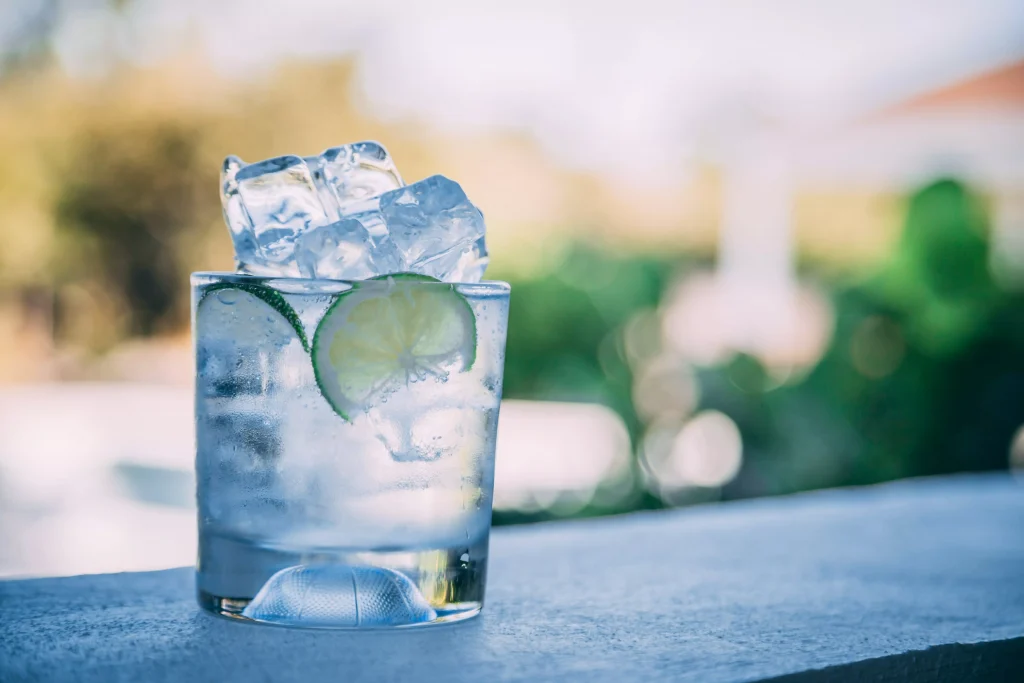 glass of water full of ice and slices of lime