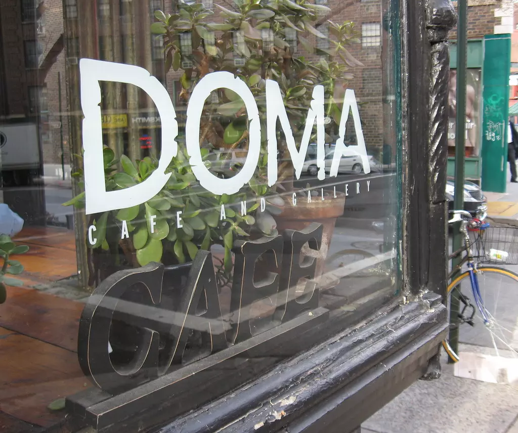 a white color logo on a glass window of a coffee shop