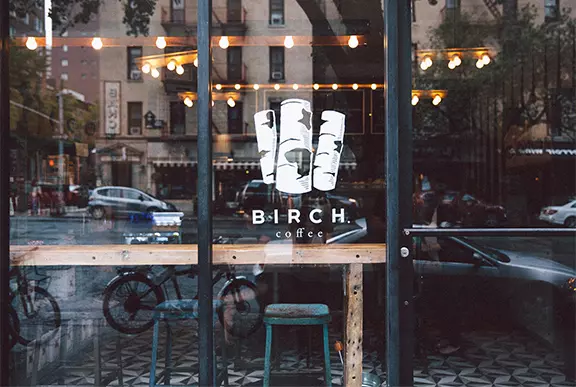 a white logo on glass of a cofee shop