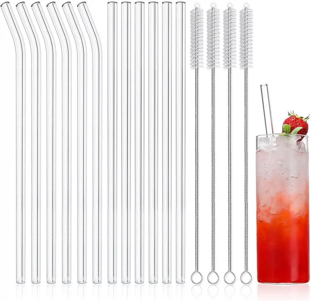 different glass straws next to a glass of strawberry juice