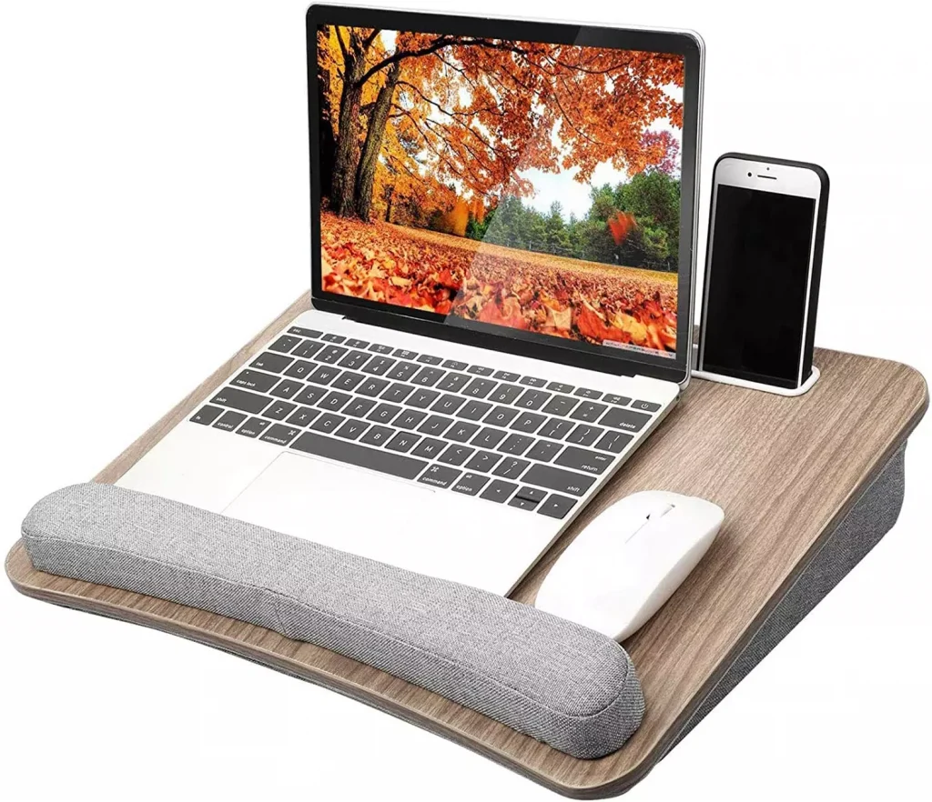 a laptop, phone and a mouse on a small wooden desk