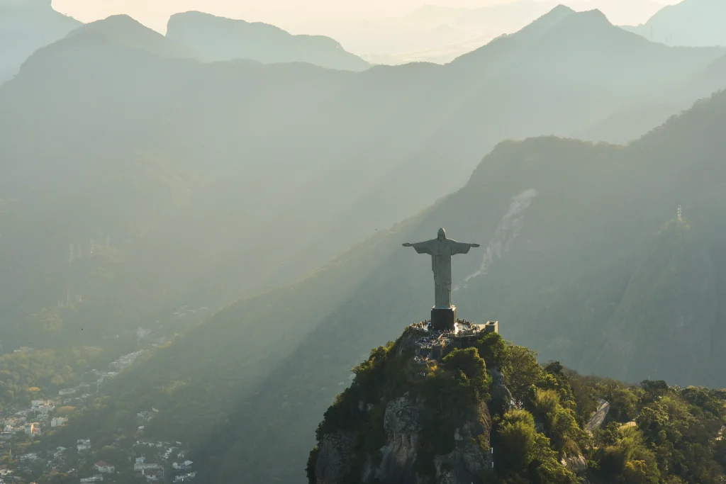 a statue on the hill above a city