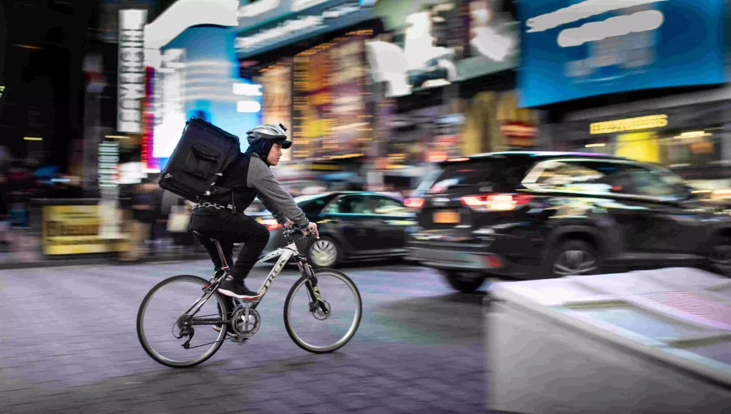 a guy with a big backpack on his bike