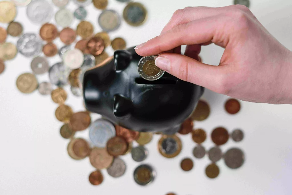 a person putting coins in a piggy bank