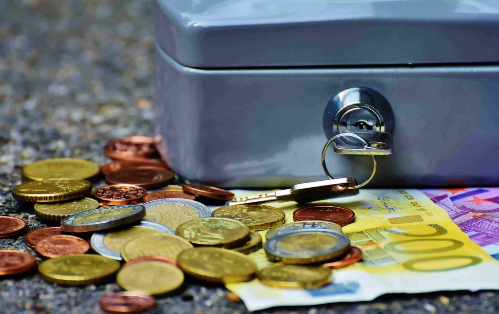 a key in a box next to some coins and paper bills