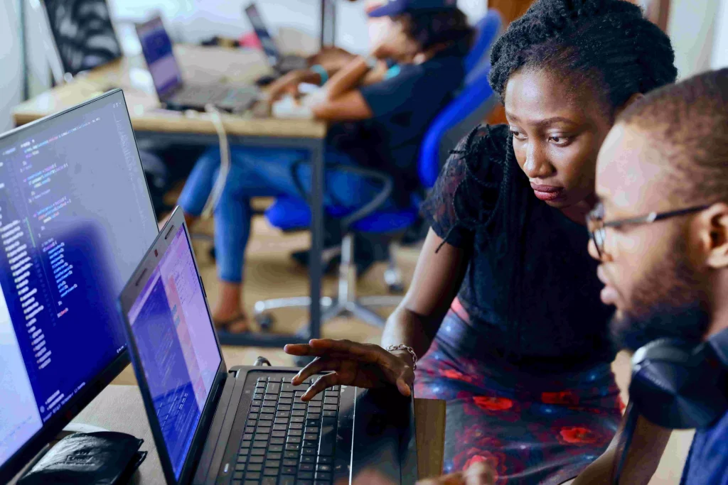 a man and a women looking at a laptop screen