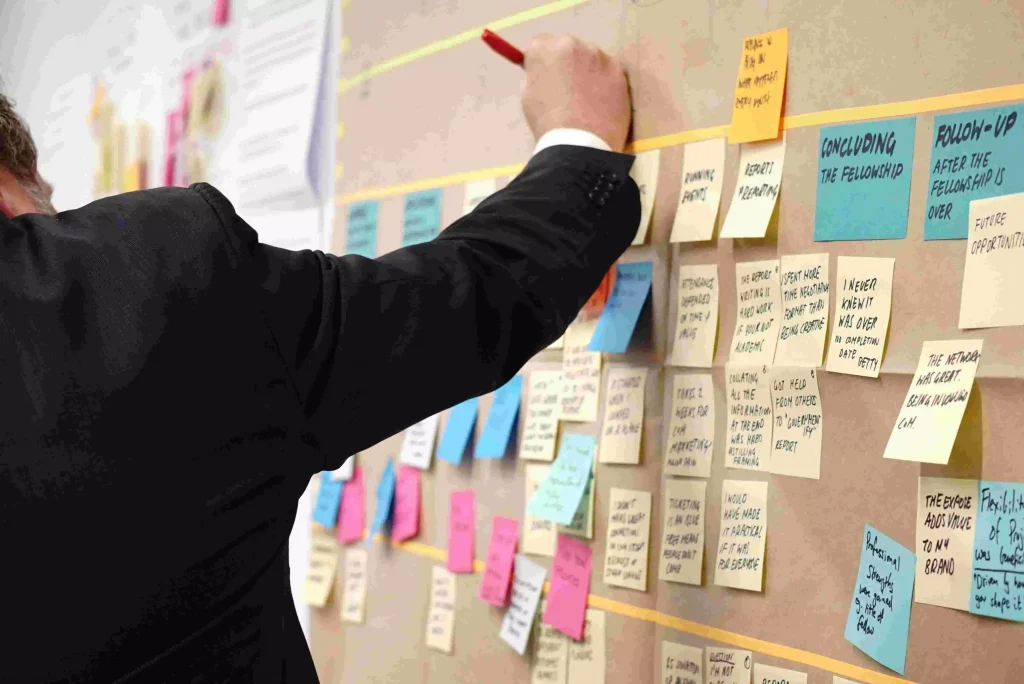 a man in a suit writing something on a board