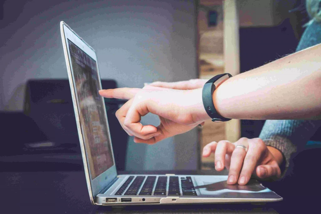 two persons working on a laptop