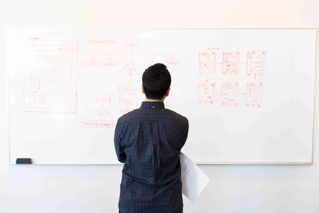 a guy looking at a whiteboard