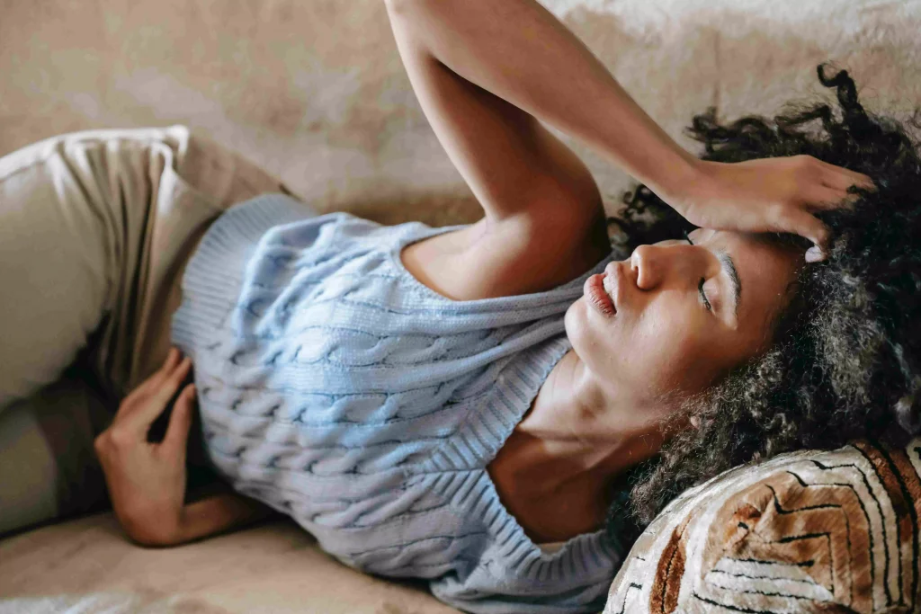 a girl in a blue tank top laying on the bed