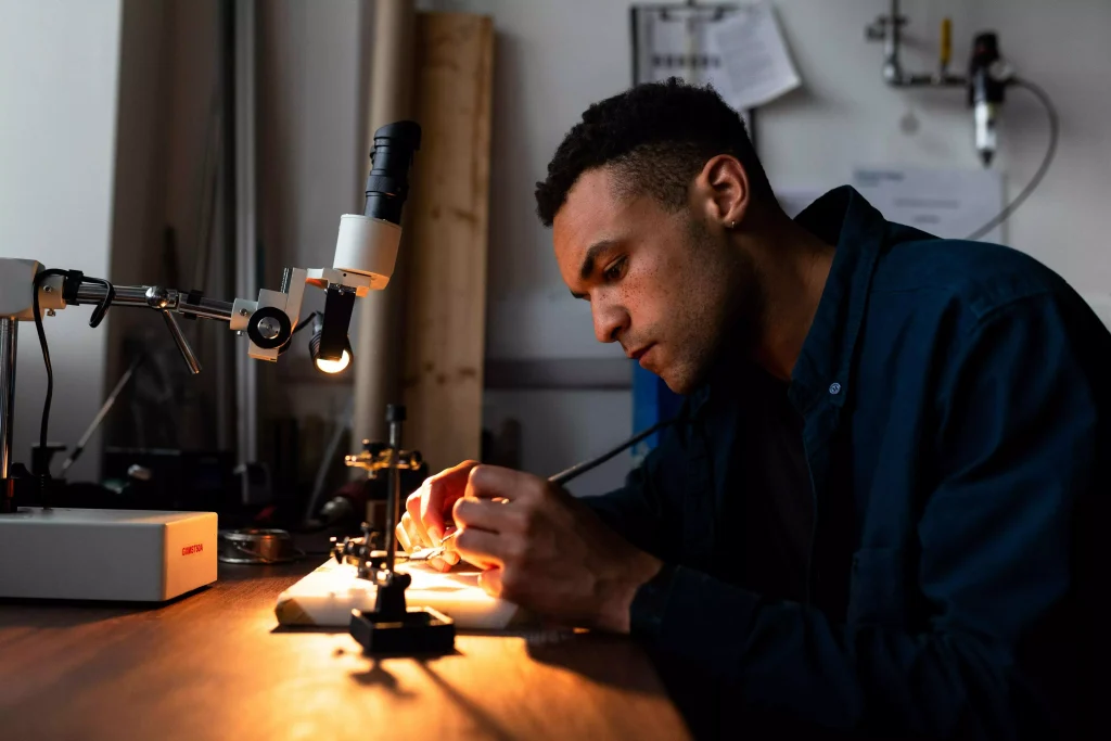 a guy looking at something through a microscope