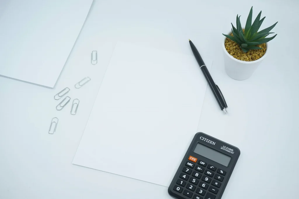 a pen and a calculator on white paper