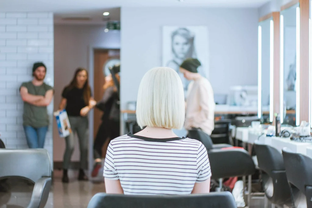 a women with blonde hair sitting in a chair 