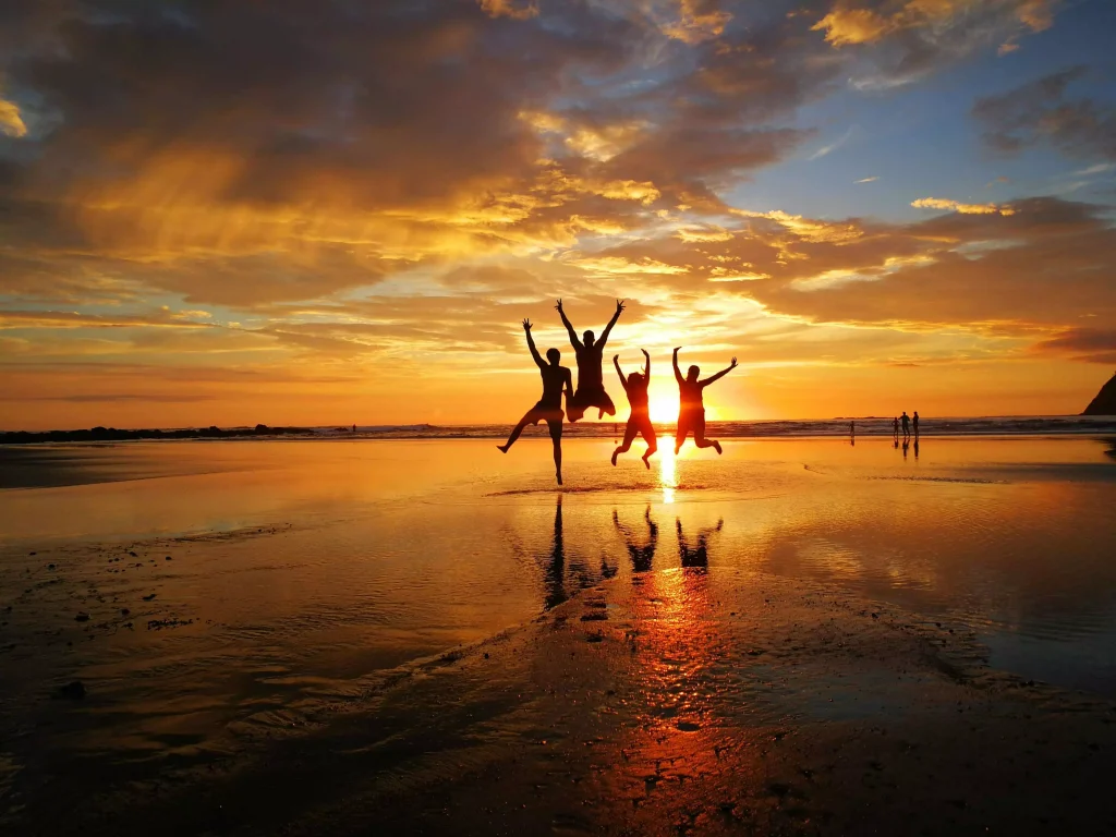 people swimming in the sea at the time of the sunset