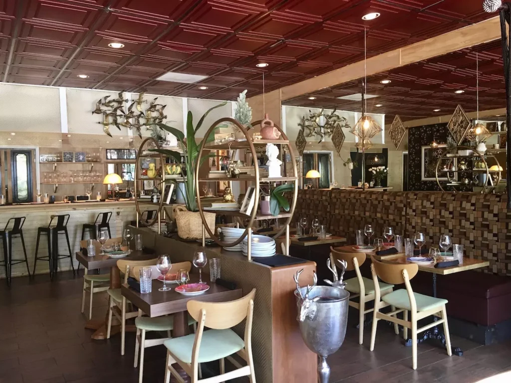 an interior of a restaurant with big green plants